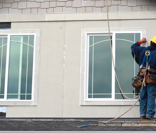 worker on roof installing new windows